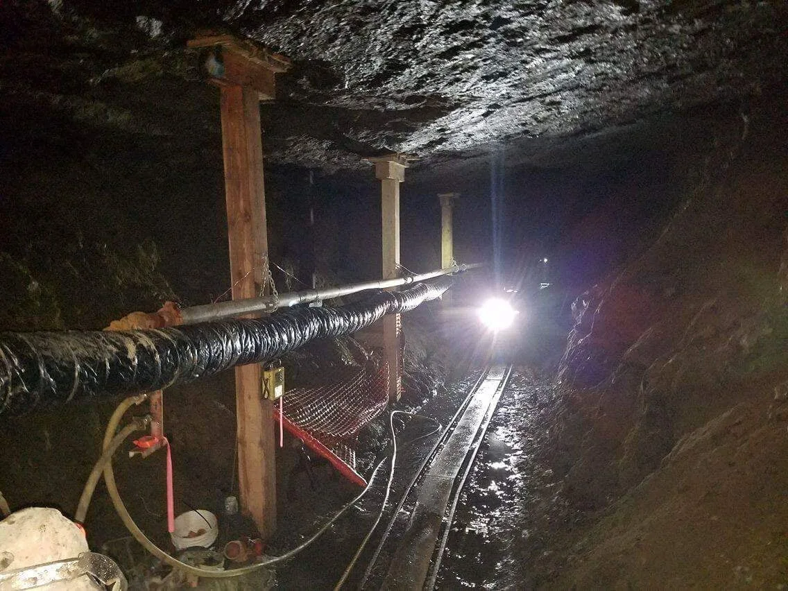 Timber supports and underground access with utility lines.